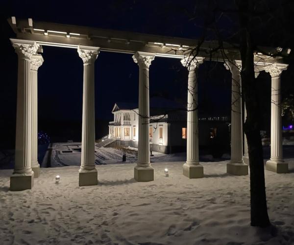 Iltavalaistu Söderlångvikin kartano lumisessa maisemassa.