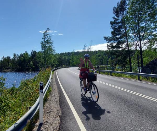 Pyöräilijä maantiellä, järvi