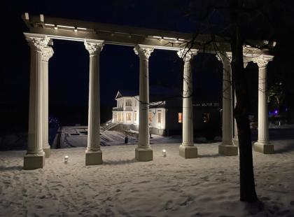 Iltavalaistu Söderlångvikin kartano lumisessa maisemassa.