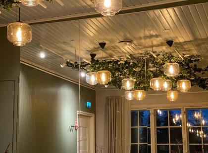 Café Adjutantin valaisimia ja pöytiä.