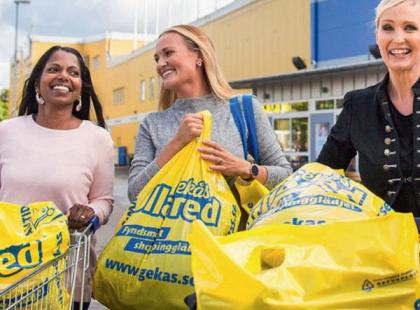 Kolme iloista shoppailijaa Gekås Ullaredin edessä.