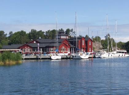 Brudhäll - punainen hotellirakennus, meri, purjeveneitä