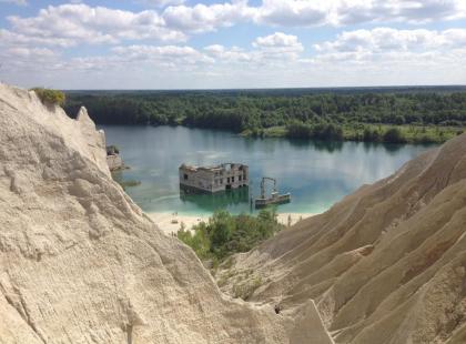 Rummun kalkkikivivuoria ja vankilan rauniot järvellä.