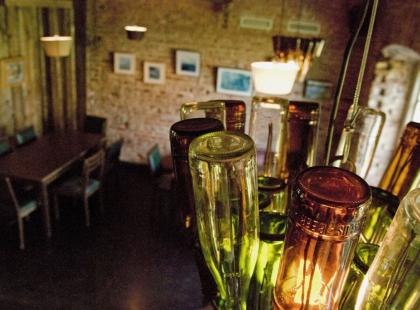 Krog 14 ravintolan pulloista tehty valaisin ravintolasalissa.