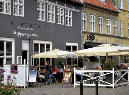 Ravintola Bryggengårdenin harmaa kivinen talo ja terasseja.