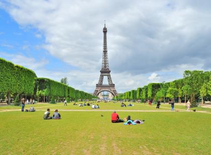 Eiffel-torni ja ihmisiä puistossa. Kuva FranceGuide info.