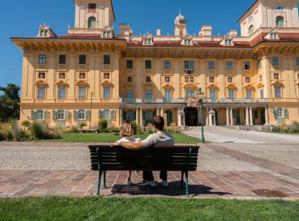 Kaksi ihmistä penkillä Esterházyn linnan edessä. ©Austria Tourism.